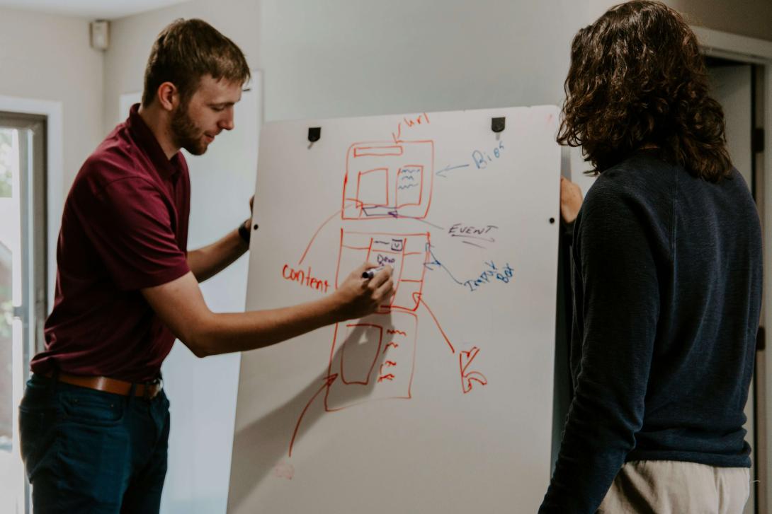 people writing strategy ideas in a board